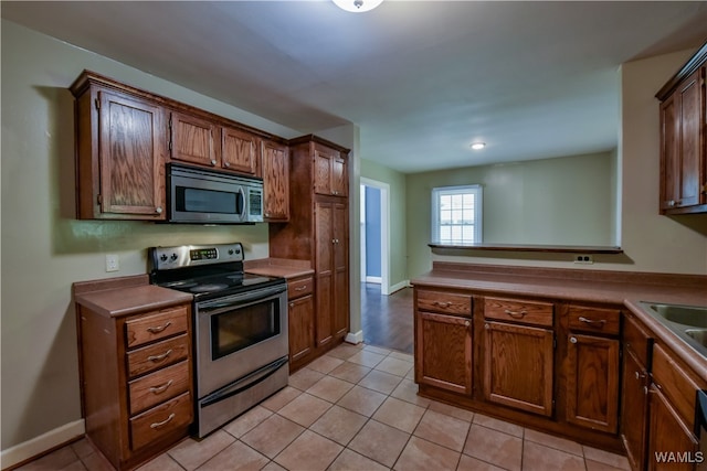 kitchen with light tile patterned floors and appliances with stainless steel finishes