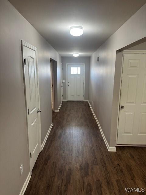 doorway to outside with baseboards and dark wood-style flooring