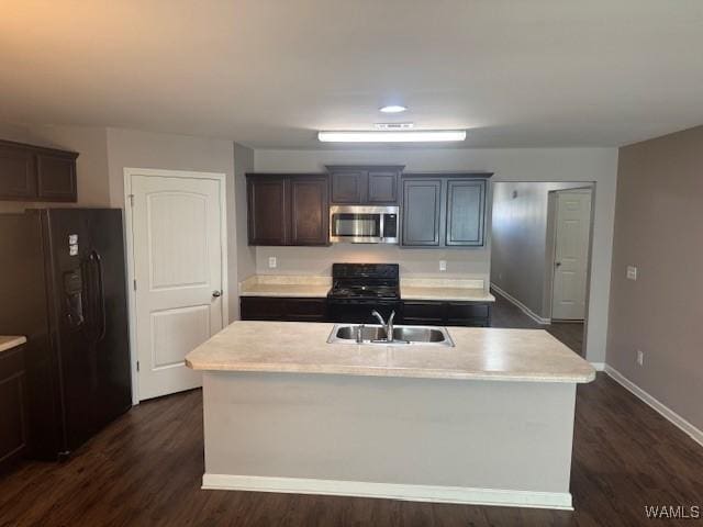 kitchen featuring a sink, dark wood-type flooring, black appliances, and light countertops