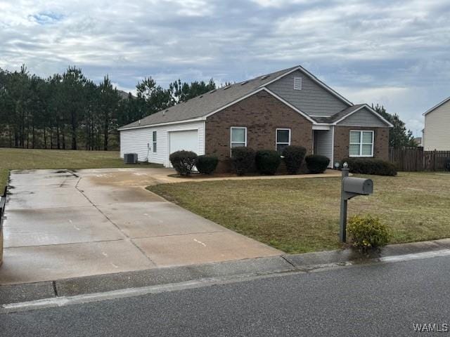 single story home featuring brick siding, a front lawn, fence, concrete driveway, and an attached garage