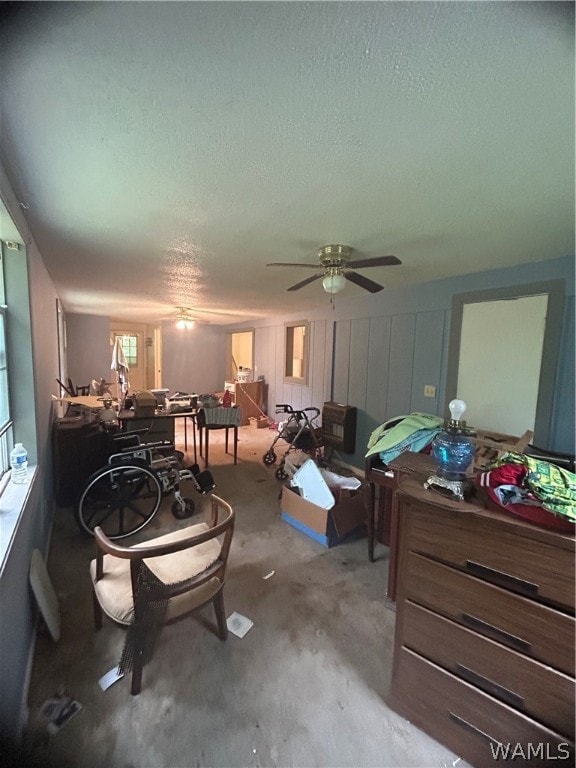 carpeted living room with a textured ceiling and ceiling fan