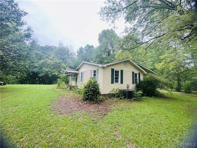 view of property exterior with central AC unit and a lawn