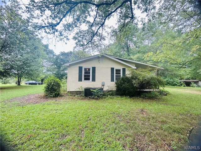 view of side of home with a lawn and central air condition unit