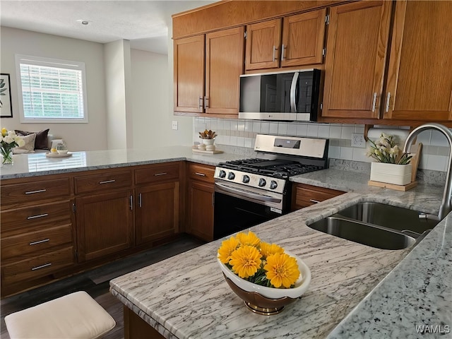 14541 Keenes Mill Rd, Coaling, AL 35453 - kitchen with appliances with stainless steel finishes, a sink, a peninsula, light stone counters, and decorative backsplash