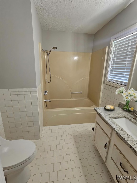 14541 Keenes Mill Rd, Coaling, AL 35453 - bathroom with tile walls, vanity, bathtub / shower combination, toilet, and a textured ceiling