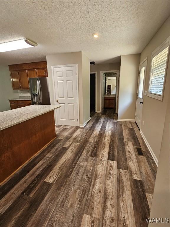 14541 Keenes Mill Rd, Coaling, AL 35453 - kitchen with stainless steel fridge, a textured ceiling, light countertops, dark wood-style floors, and baseboards