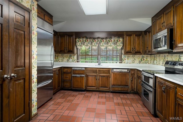 5204 Dove Creek Ave, Northport, AL 35473 - kitchen featuring stainless steel appliances, a sink, brick patterned floors, and light countertops