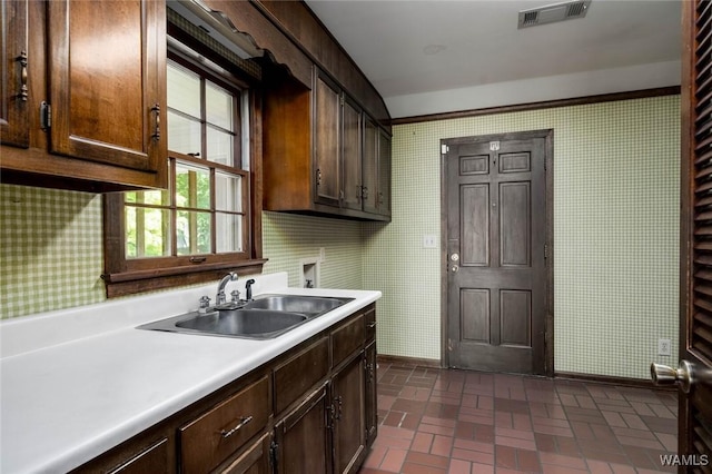 5204 Dove Creek Ave, Northport, AL 35473 - kitchen with a sink, baseboards, wallpapered walls, brick patterned floors, and light countertops