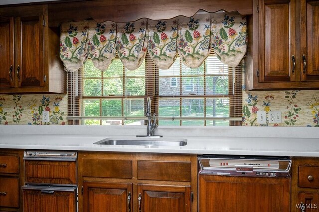 5204 Dove Creek Ave, Northport, AL 35473 - kitchen featuring paneled dishwasher, a sink, light countertops, and brown cabinetry
