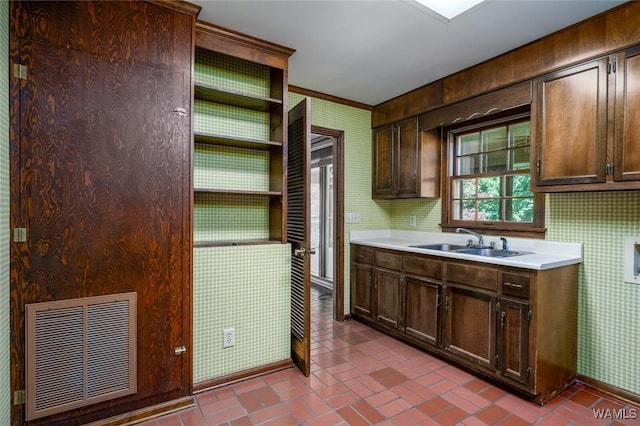 5204 Dove Creek Ave, Northport, AL 35473 - kitchen featuring wallpapered walls, a sink, brick patterned floors, open shelves, and light countertops