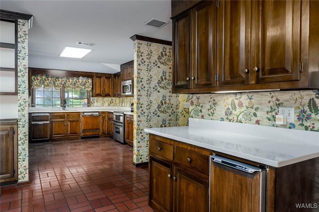 5204 Dove Creek Ave, Northport, AL 35473 - kitchen featuring appliances with stainless steel finishes, brick patterned floors, wallpapered walls, light countertops, and a sink