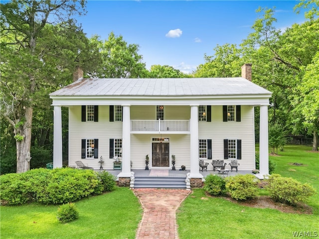 neoclassical / greek revival house featuring a front lawn and a porch