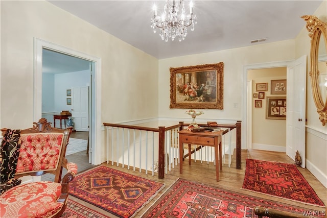 corridor with hardwood / wood-style floors and a notable chandelier