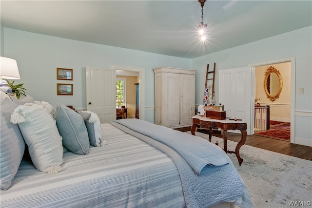 bedroom featuring connected bathroom and wood-type flooring