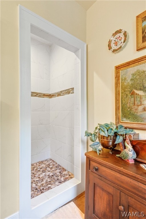 bathroom with vanity, wood-type flooring, and tiled shower