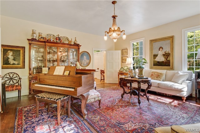 miscellaneous room with a notable chandelier and dark wood-type flooring