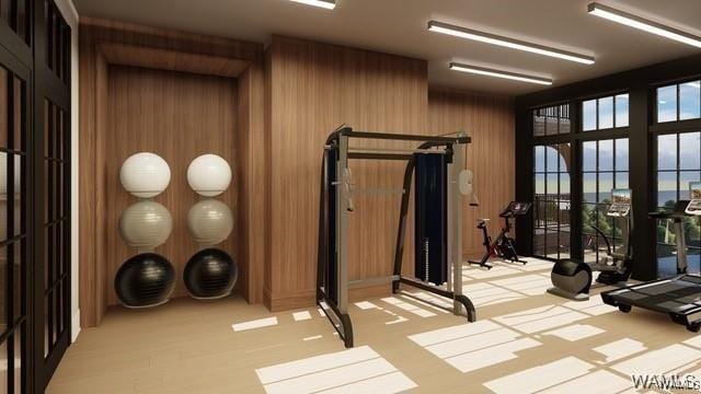workout room with wooden walls and light colored carpet