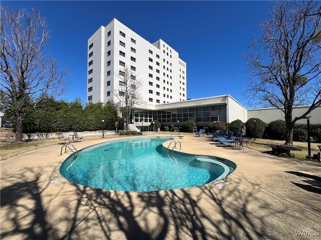 community pool featuring a sunroom and a patio