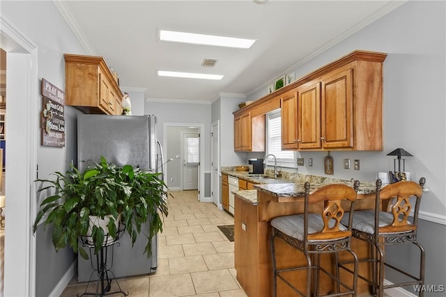 kitchen featuring light tile patterned floors, white dishwasher, light stone countertops, crown molding, and sink