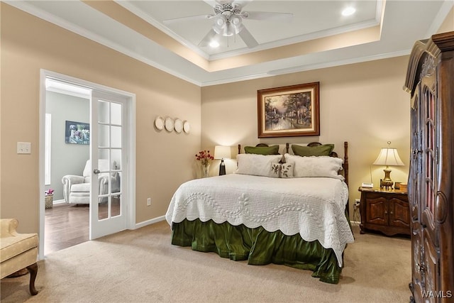 carpeted bedroom featuring french doors, ceiling fan, ornamental molding, and a raised ceiling