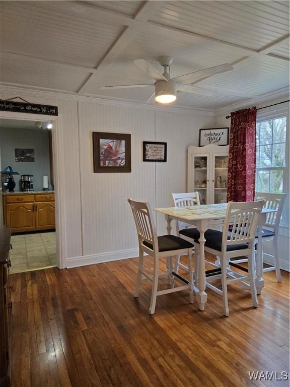 dining space with coffered ceiling, crown molding, ceiling fan, and wood-type flooring