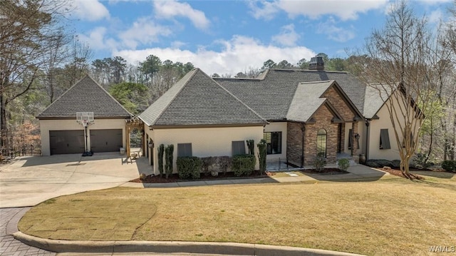 1901 Point Clear Rd, Tuscaloosa, AL 35406 - french country style house featuring stone siding, a front yard, concrete driveway, and an attached garage