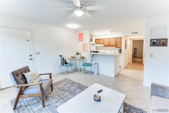 living room featuring light tile patterned floors, visible vents, and ceiling fan