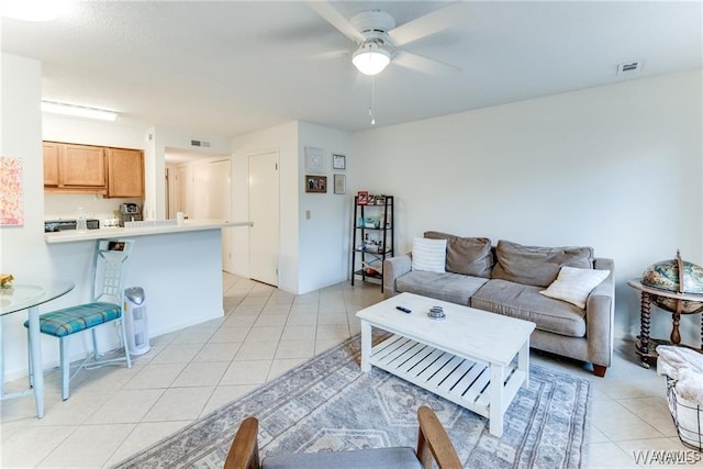 living room featuring light tile patterned floors, visible vents, and ceiling fan