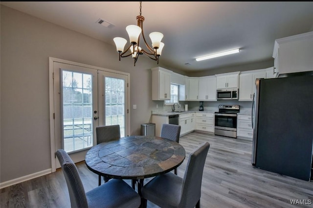 17818 Alecia Dr, Vance, AL 35490 - dining space featuring a chandelier, french doors, light wood-type flooring, and baseboards