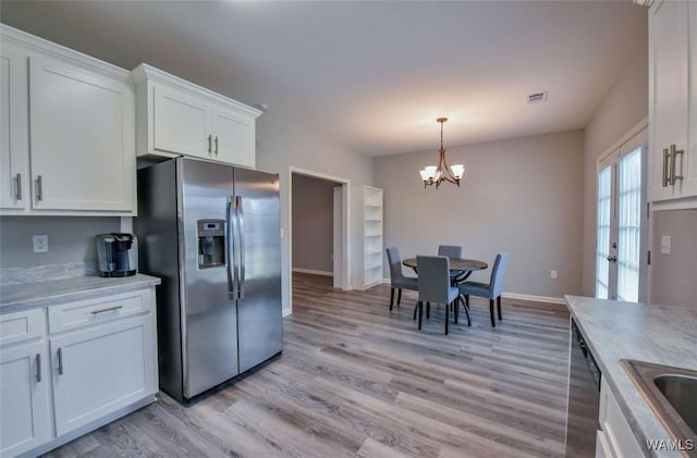 17818 Alecia Dr, Vance, AL 35490 - kitchen with stainless steel refrigerator with ice dispenser, light wood-style flooring, a chandelier, and white cabinetry