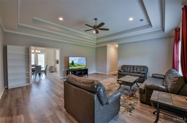 17818 Alecia Dr, Vance, AL 35490 - living room with a raised ceiling, a chandelier, a ceiling fan, wood finished floors, and crown molding