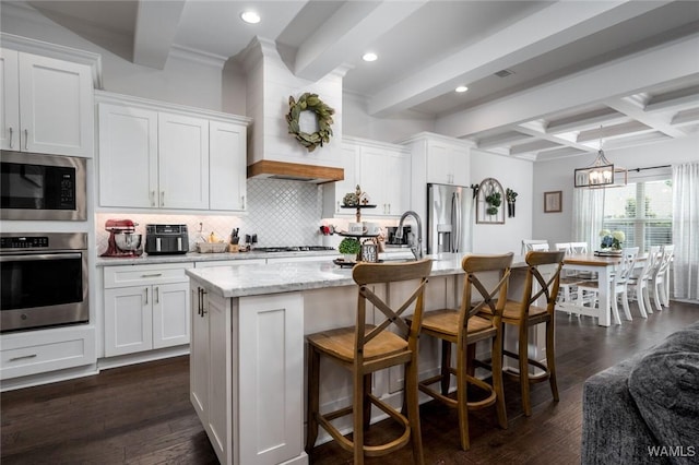 11210 Davis Pl, Northport, AL 35475 - kitchen featuring stainless steel appliances, tasteful backsplash, beam ceiling, white cabinets, and a center island with sink