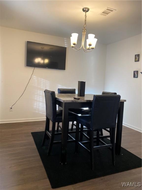 dining area with a chandelier and dark hardwood / wood-style flooring