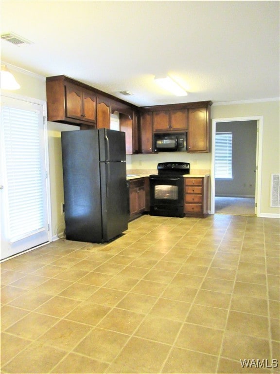 kitchen featuring light tile patterned flooring, dark brown cabinetry, ornamental molding, and black appliances