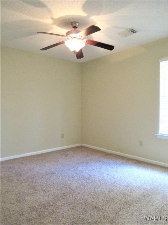 carpeted spare room featuring ceiling fan