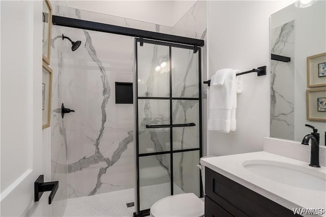 bathroom featuring vanity, toilet, and an enclosed shower