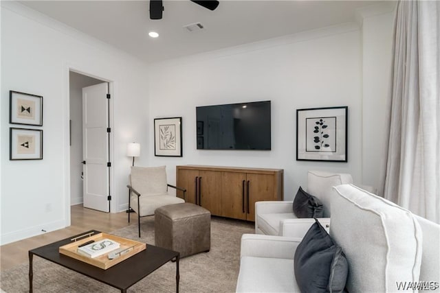 living room featuring crown molding, light hardwood / wood-style floors, and ceiling fan