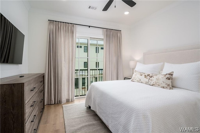 bedroom featuring ceiling fan, light hardwood / wood-style floors, multiple windows, and crown molding