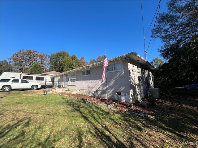 view of side of home featuring a yard and central AC