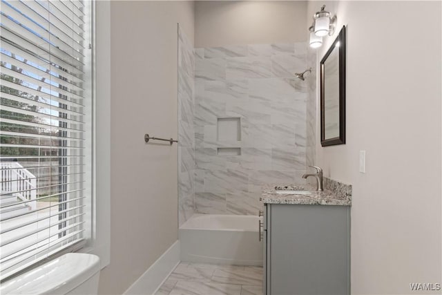 bathroom with toilet, vanity, baseboards, marble finish floor, and tub / shower combination