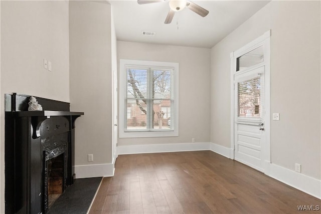 interior space featuring dark wood-type flooring, a wealth of natural light, visible vents, and baseboards