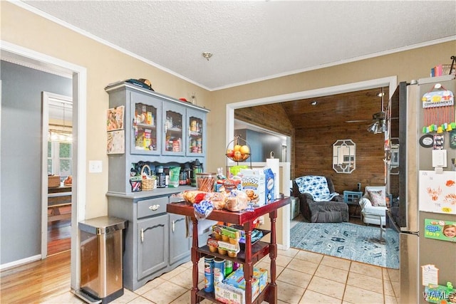 15551 Oakwood Dr, Brookwood, AL 35444 - dining room featuring wooden walls, ornamental molding, light tile patterned floors, and a textured ceiling