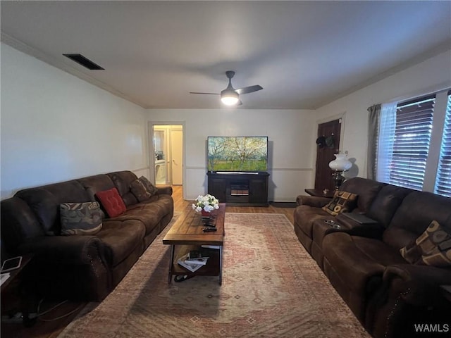 living area with ceiling fan, wood finished floors, and visible vents