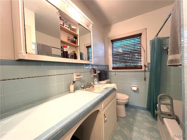 bathroom featuring wainscoting, toilet, a shower with shower curtain, vanity, and tile walls