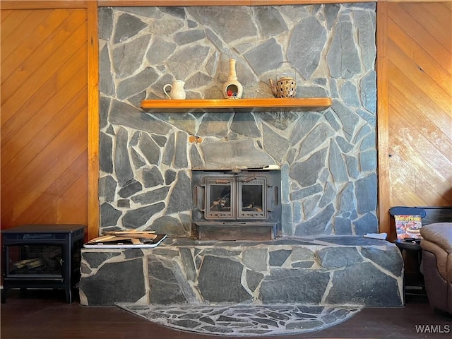 interior details with a wood stove, wooden walls, and wood finished floors