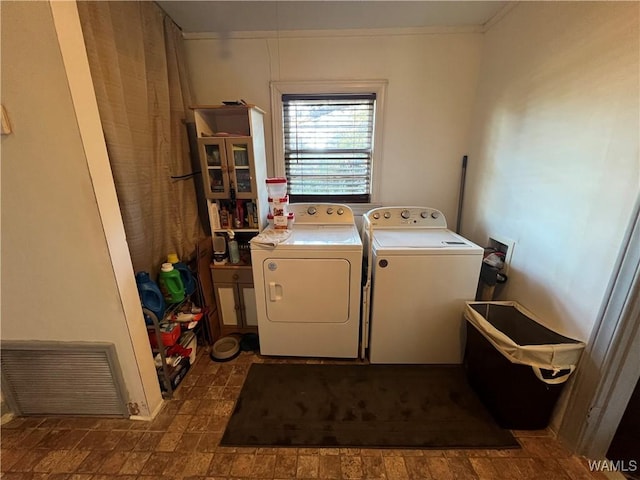 clothes washing area featuring crown molding, laundry area, visible vents, and independent washer and dryer