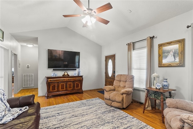 living room with light hardwood / wood-style flooring, vaulted ceiling, and ceiling fan