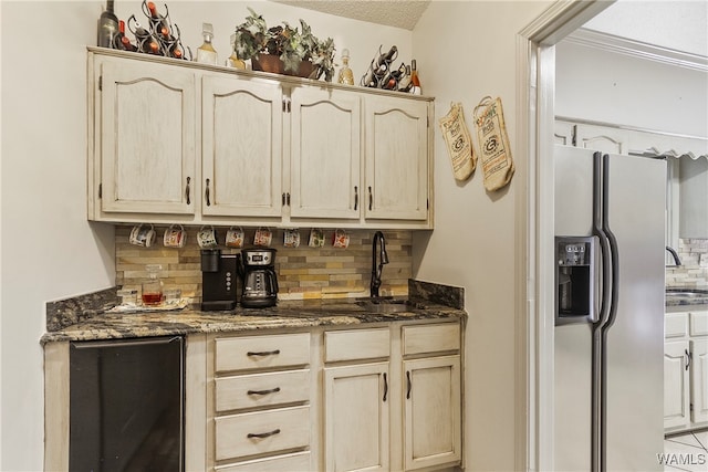 bar featuring tasteful backsplash, stainless steel fridge with ice dispenser, sink, and dark stone counters