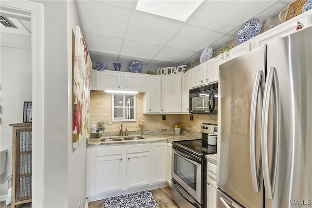 kitchen featuring white cabinets, stainless steel appliances, light hardwood / wood-style floors, and sink