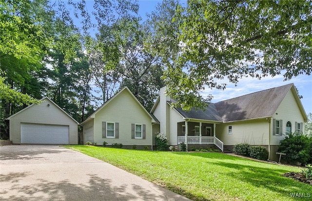 view of front of property with a front lawn, covered porch, an outdoor structure, and a garage